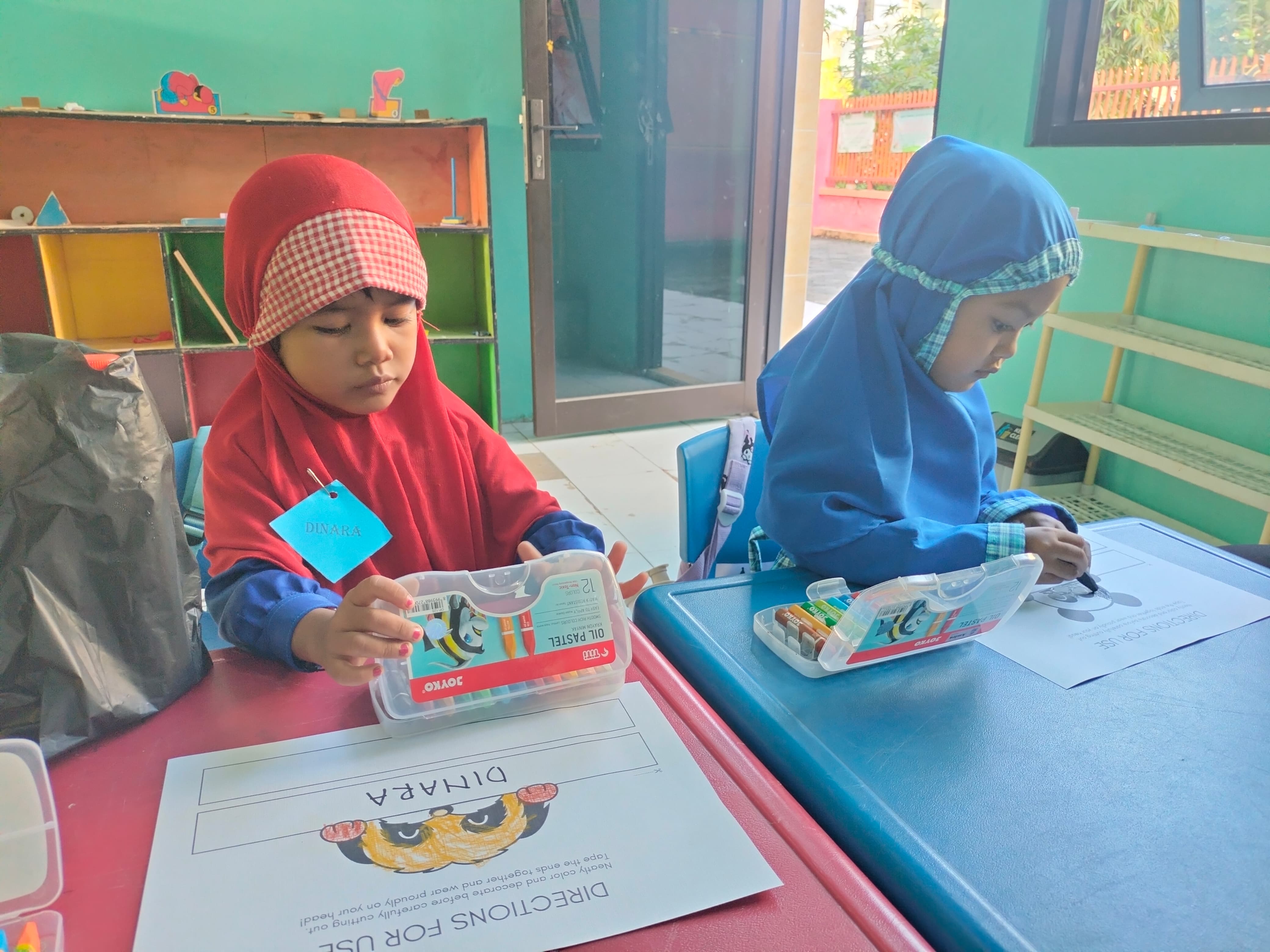 Dinara dan Amira mewarnai topi nama