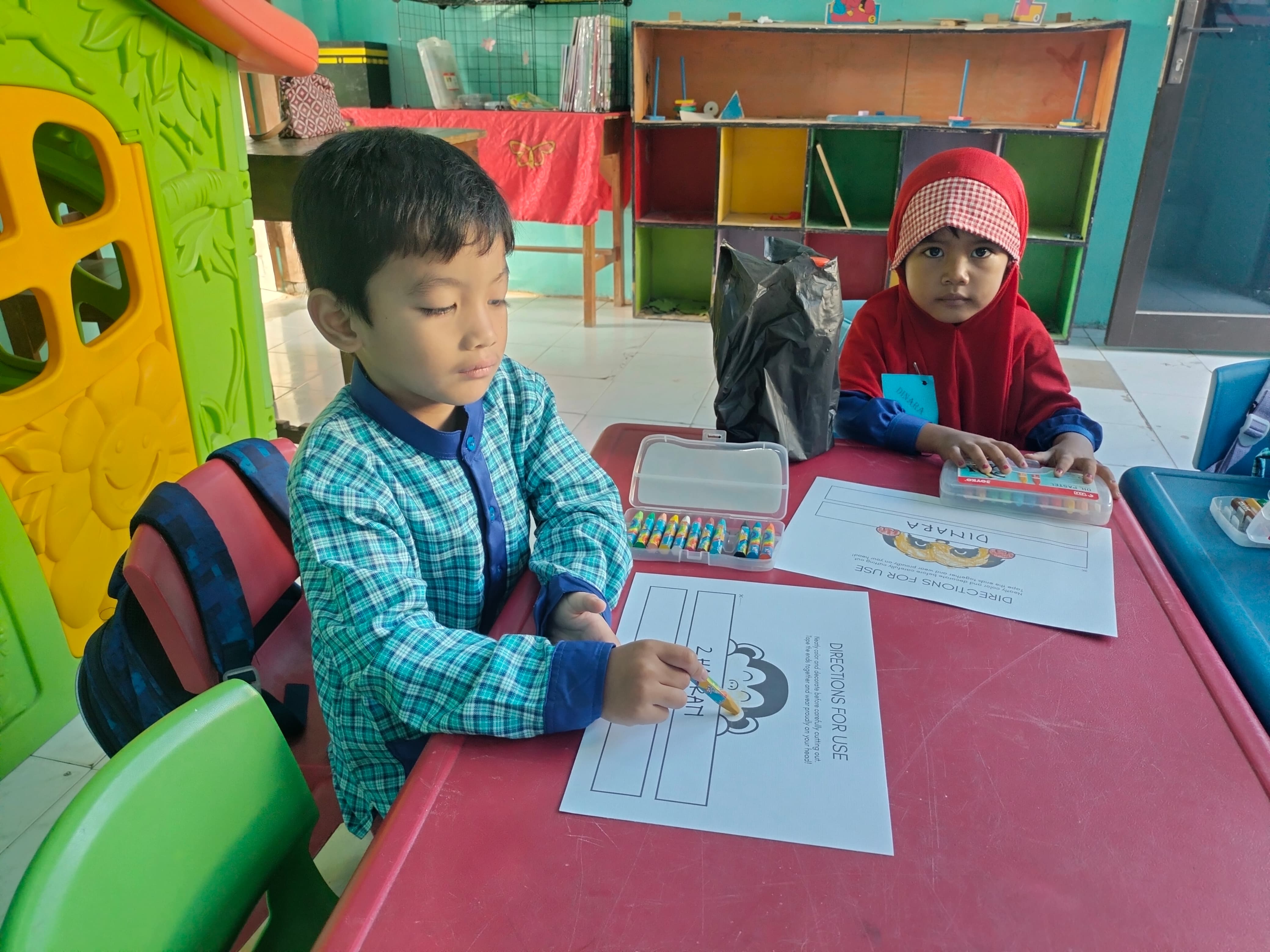 Zhafran dan Dinara mewarnai topi nama